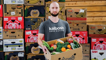 Kaibosh Wellington volunteer Daniel with box of food for recipients.